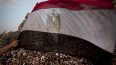 Demonstranti na protivládním protestu na náměstí Tahrír mávají egyptskou vlajkou