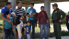 Americký policista mluví s Mexičany, kteří nelegálně překročili hranice