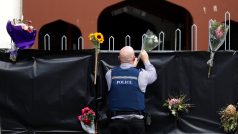Policista pokládá květiny ke vstupu do mešity v Christchurch