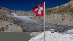 Švýcarská vlajka u vchodu do ledové jeskyně na ledovci Rhone (ilustrační foto)