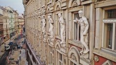Osamělá mužská postava na fasádě paláce Adria