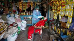 Zdravotnice provádí test na covid v obchodě s potravinami ve městě Ahmadábád