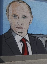 Žena v krymském Simferomolu prochází kolem graffiti, které znázorňuje ruského prezidenta Vladimira Putina