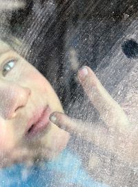 Chlapec evakuovaný z Aleppa ukazuje vítězné gesto