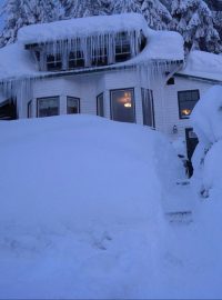 Dům na Aljašce pokrytý sněhem a ledem.