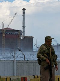 Voják s ruskou vlajkou na uniformě poblíž Záporožské jaderné elektrárny