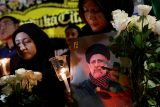 Žena s fotografií zesnulého íránského prezidenta Ebrahima Raisiho se účastní vigilie k uctění jeho památky a památky dalších obětí, které zahynuly při havárii vrtulníku, před íránským velvyslanectvím v Jakartě, 20. května
