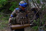 Ukrajinský voják nese v Charkovské oblasti dělostřeleckou munici do houfnice D-20 (fotografie z 21. května 2024)