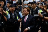 Lawrence Lau Wai-chung je doprovázen policií před budovu soudu v Západním Kowloonu poté, co byl 30. května zproštěn obvinění podle zákona o národní bezpečnosti