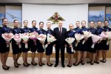 Ruský prezident Vladimir Putin (uprostřed) pózuje se studentkami Vyšší vojenské letecké školy Anatolije Serova v Krasnodaru poté, co jim předal květiny v předvečer Mezinárodního dne žen, 7. března 2024