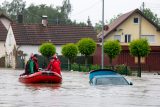 Záchranáři ve městě Babenhausen projíždějí zaplavenou ulicí v nafukovacím člunu