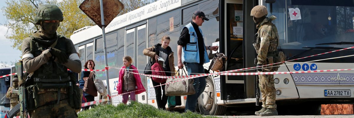 Civilisté z oblasti nedaleko Azovstalu nastupují do autobusu v dočasném ubytovacím centru u obce Bezimenne