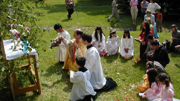 Kněz kadidlem okuřuje venkovní oltář