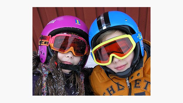 Mladí lyžaři v helmách