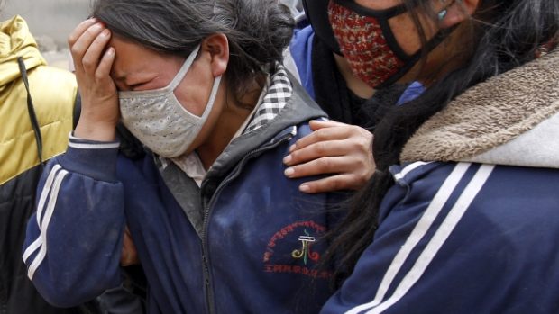 Matka pláče poté, co záchranáři vytáhli po zemětřesení ze školy tělo jejího syna