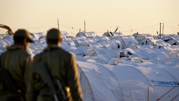 tuniští vojáci pozorují stanové městečko pro uprchlíky na hranicích s Libyií