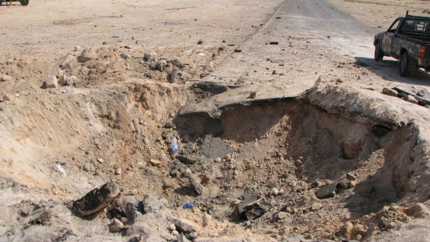 Kráter po dopadu rakety u libyjského města Briga
