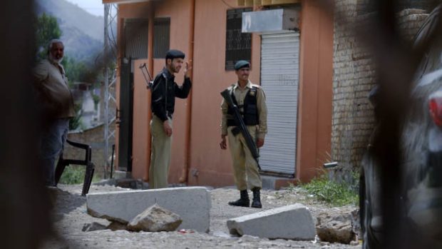 Pákistánský voják a policista hlídají ulici v blízkosti sídla v Abbottábádu, v němž se ukrýval Usáma bin Ládin