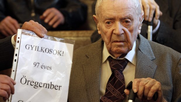 Sándor Képíró u soudu drží nápis Jste vrazi 97letého muže