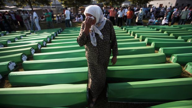 Bosenská žena pláče mezi rakvemi ostatků obětí před začátkem obřadu v památníku blízko Srebrenice