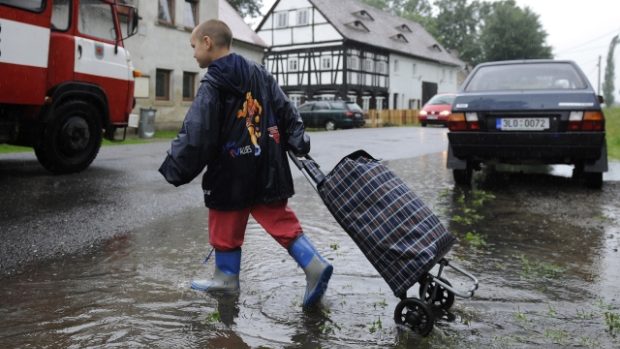 Jeden z evakuovaných opouští svoje obydlí v obci Víska u Višňové na Liberecku