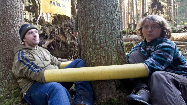 Ekologičtí aktivisté připoutaní kovovými trubkami ke stromům