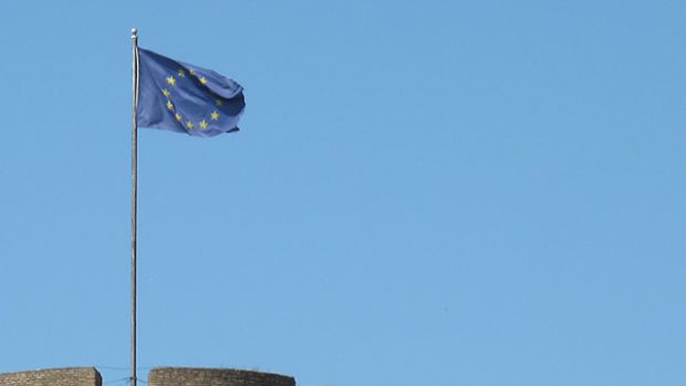 vlajka EU nad středověkou hradbou