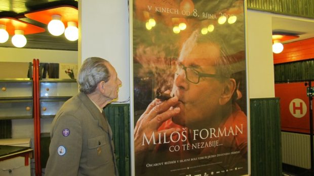 Jeden z pamětníků si prohlíží plakát, na kterém je Miloš Forman