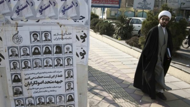 Íránský duchovní míjí staré volební plakáty v centru Teheránu