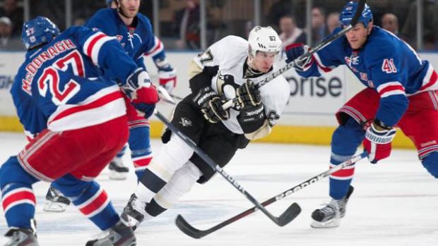 Sidney Crosby v obklíčení protihráčů v utkání NHL New York Rangers - Pittsburgh Penguins