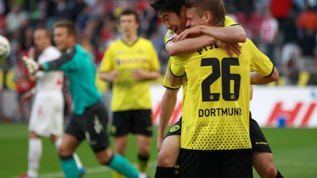 Dortmundský fotbalista Shinji Kagawa oslavuje s Lukaszem Piszczekem svůj gól do sítě Kolína