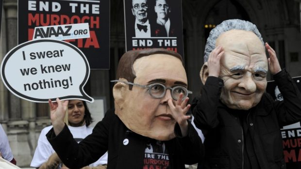 Demonstranti převlečení za Jamese a Ruperta Murdocha demonstrují před nejvyšším soudem v Londýně