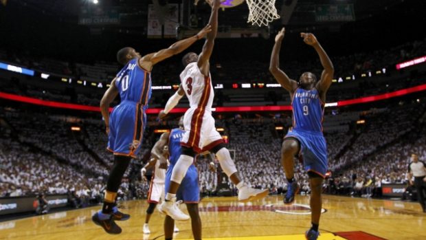 Miami Heat&#039;s Dwyane Wade (C) shoots between Oklahoma  City Thunder&#039;s Russell Westbrook  (L) and Serge Ibaka (R) in the first half during Game 4 of the NBA basketball finals in Miami, Florida, June 19, 2012