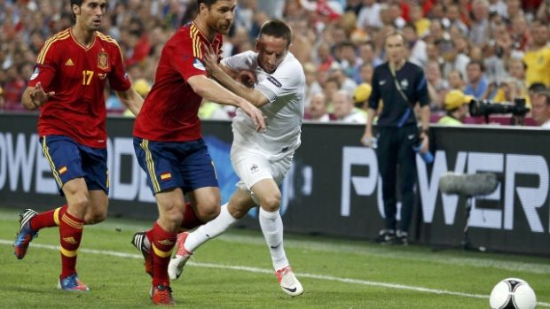 Španěl Xabi Alonso (uprostřed) v souboji s Francouzem Ribérym