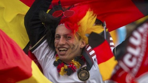Mladík s německou vlajkou fandí národnímu týmu v ulicích Berlína
