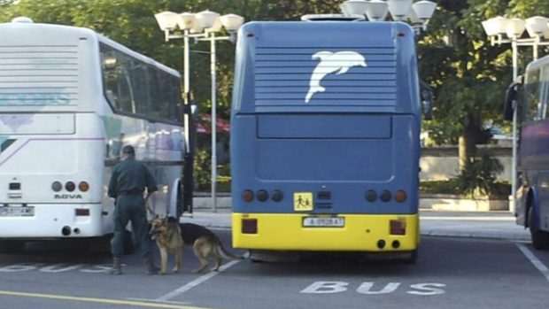 Bulharský policista se psem ohledává další zaparkované autobusy u letiště v Burgasu