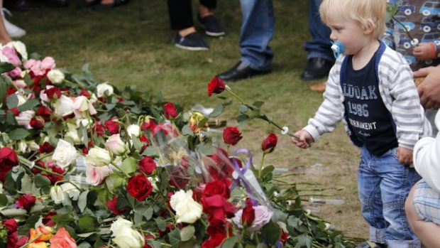 Dítě pokládá růži za oběti loňského vraždění Anderse Breivika u katedrály v norském Oslu