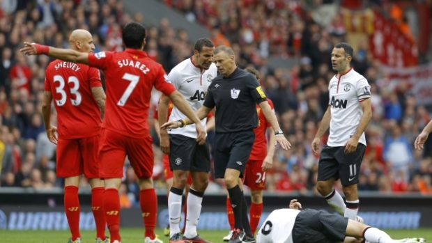 Hráč Manchesteru United Jonny Evans leží na trávníku po střetu s liverpoolským Jonjo Shelveym