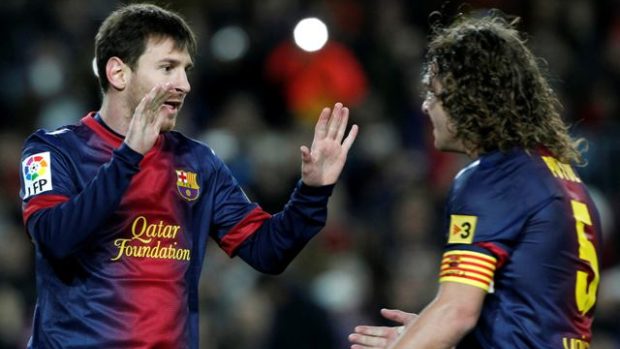 Fotbalista Barcelony Lionel Messi (vlevo) a jeho spoluhráč Carles Puyol slaví gól do sítě Osasuny ve španělské lize