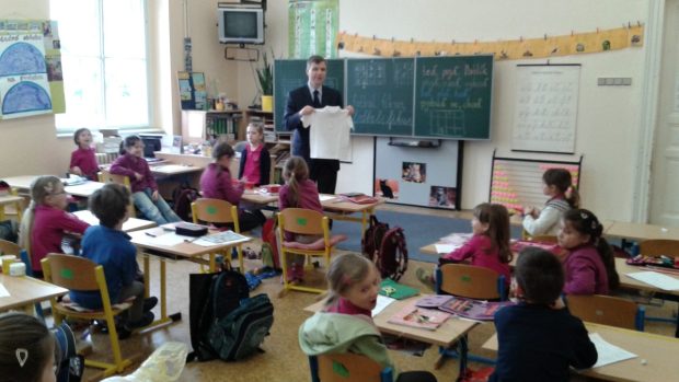 Ředitel Jindřich Koudela ukazuje žákům novou uniformu