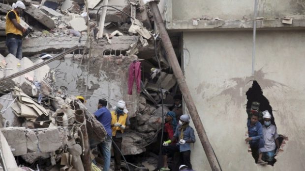 Záchranáři pátrají po dělnících v sutinách zřícené budovy u Dháky.