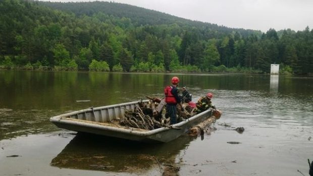 Hasiči pomáhají s čištěním hladiny Husinecké přehrady po povodni