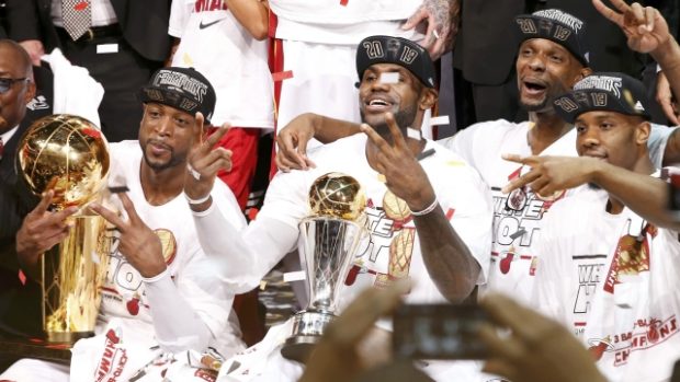 Hráči Miami Dwyane Wade (vlevo), LeBron James (uprostřed) a Chris Bosh slaví titul šampionů v NBA