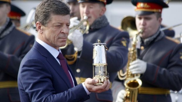 Vicepremiér Dmitrij Kozak drží lampu s olympijským ohněm po přistání v Moskvě