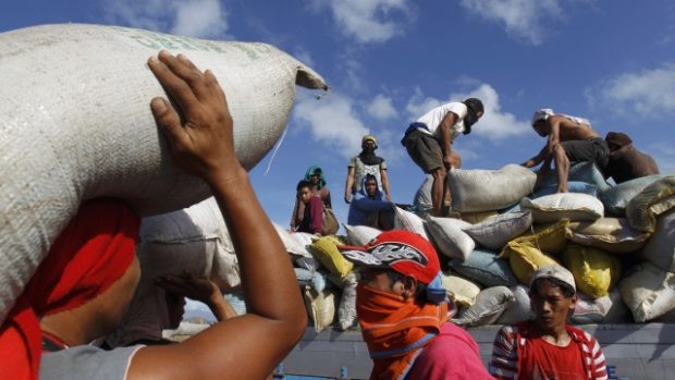 Filipínci vynášejí pytle rýže ze skladiště, které poničil tajfun Haiyan