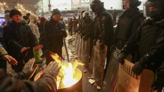 Protestující se v Kyjevě zahřívají u ohňů v přítomnosti pořádkových jednotek