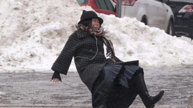 Žena padá na zmrzlém chodníku na Roosweltově ostrově v New Yorku