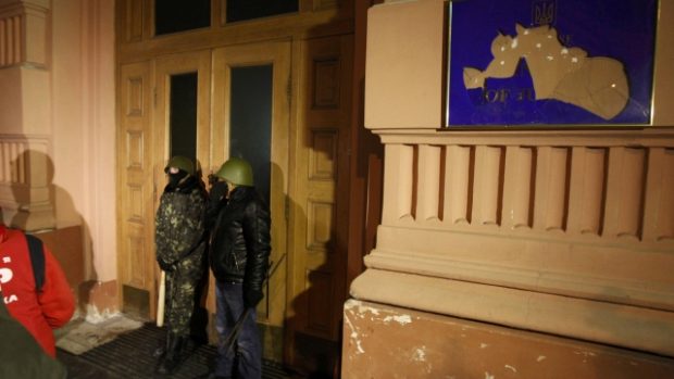 Protivládní demonstranti v Kyjevě střeží vchod do budovy ministerstva spravedlnosti, kterou obsadili
