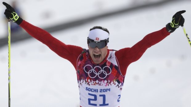 Švýcar Dario Cologna se raduje v cíli skiatlonu ze zlaté olympijské medaile