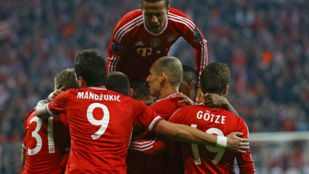 Hráči Bayernu slaví v hloučku branku Bastiana Schweinsteigera